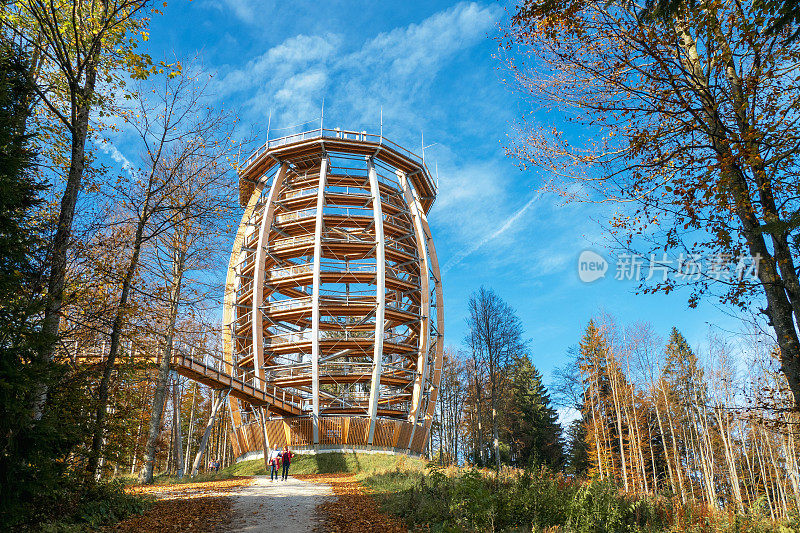 资深徒步旅行者经过奥地利Grünberg, OÖ上新建的木制观景塔“Baumwipfelpfad”